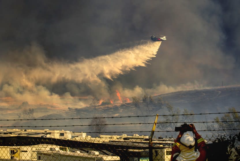 A helicopter makes a water drop on a Santa Ana wind-driven Bond fire