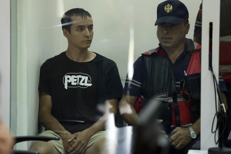 Russian Mikhail Zorin guarded by police appears at a court in Elbasan, Albania, Wednesday, Aug. 24, 2022. Two Russians and a Ukrainian were arrested for alleged espionage at a military plant in southern Albania, on Saturday, Aug. 20, 2022. Two military guards were injured by a "neo-paralyzing spray" used by the Russian while resisting arrest according to the Albanian Defence Ministry. (AP Photo/Franc Zhurda)