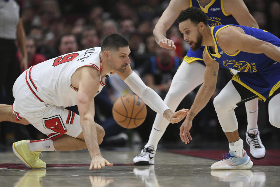 Golden State Warriors' Stephen Curry (30) battles Chicago Bulls' Nikola Vucevic (9) for the ball during the second half of an NBA basketball game Friday, Jan 12, 2024, in Chicago. (AP Photo/Paul Beaty)
