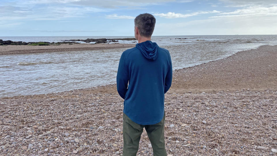 Man on beach wearing Smartwool Men's Active Mesh Hoodie back view