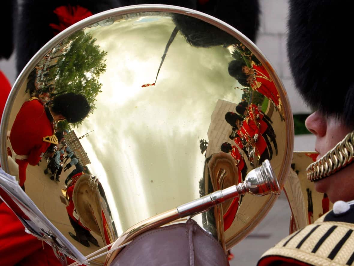 Members of the Governor General's Foot Guards are reflected as they take part in a ceremony at the Peacekeeping Monument to honour fallen peacekeepers in Ottawa on August 12, 2012. (Fred Chartrand/The Canadian Press - image credit)