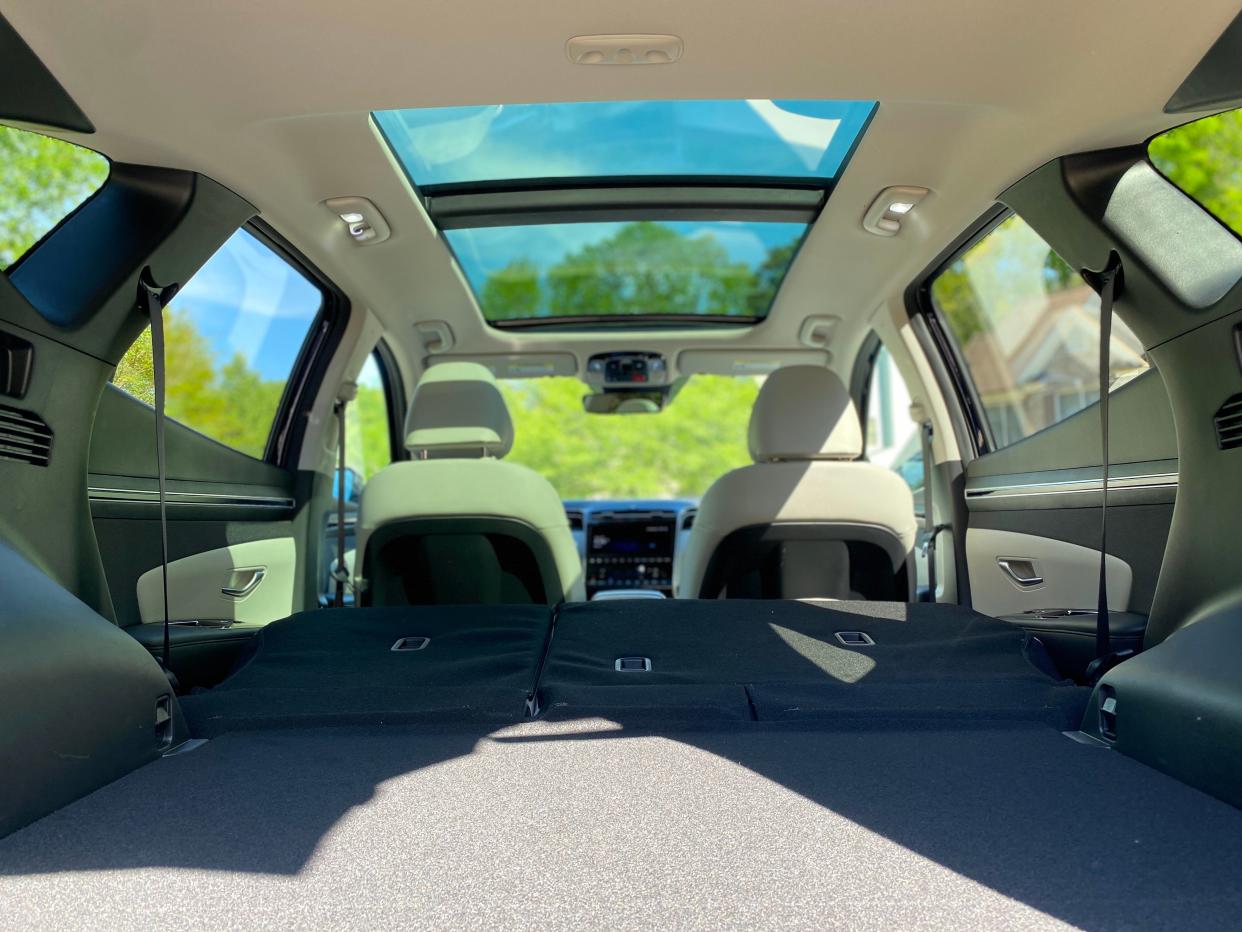 The cabin of a 2024 Hyundai Tucson Hybrid with the back seats folded.