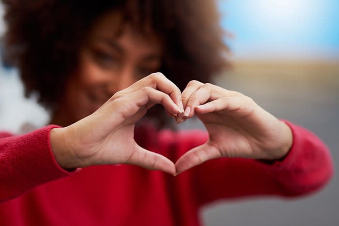 hacer el gesto de un corazón con las manos