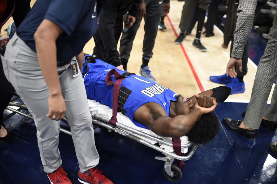 Orlando Magic forward Jonathan Isaac is taken off the court on a stretcher after he sustained an injury during the first half of the team's NBA basketball game against the Washington Wizards, Wednesday, Jan. 1, 2020, in Washington. (AP Photo/Nick Wass)