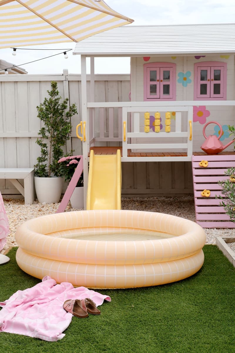 yard with astroturf, inflatable pool, and kids' play house