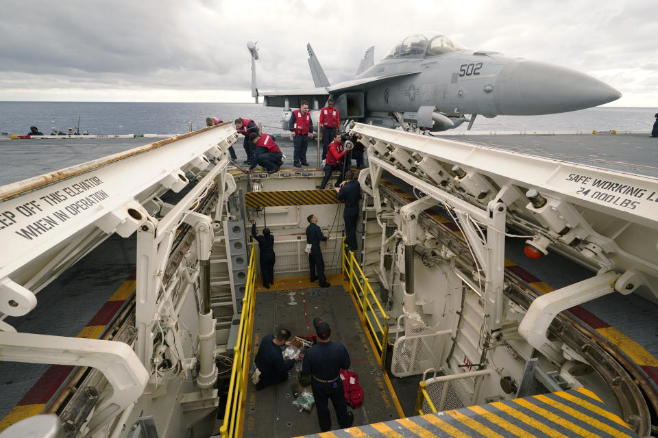 FILE - Weapons personnel work on a weapons elevator on the flight deck of the aircraft carrier USS Gerald R. Ford, Oct. 6, 2022, off the Virginia Coast. The Pentagon has ordered the Ford carrier strike group to sail to the Eastern Mediterranean to be ready to assist Israel, two U.S. officials said Sunday, Oct. 8, 2023. The USS Gerald R. Ford and its approximately 5,000 sailors and deck of warplanes will be accompanied by cruisers and destroyers in a show of force that is meant to be ready to respond to anything, from possibly interdicting additional weapons from reaching Hamas and conducting surveillance. (AP Photo/Steve Helber, File)