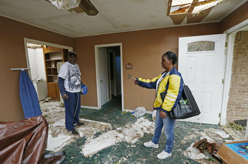 "Don't forget that ironing board," calls out Morton, Miss., resident Sandra Toney, right to a friend as she tries to remove all salvageable items from her house, Friday, April 19, 2019, as she and other area residents begin the long road of physical recovery from being hit by a possible tornado, Thursday afternoon. Strong storms again roared across the South on Thursday, topping trees and leaving a variety of damage in Mississippi, Louisiana and Texas. (AP Photo/Rogelio V. Solis)