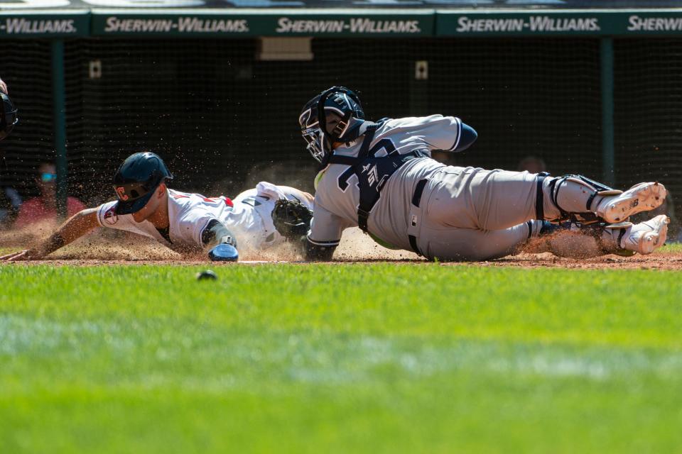 New York Yankees catcher Jose Trevino tags Guardians outfielder Steven Kwan out at home plate during the eighth inning of Sunday's game at Progressive Field. The Guardians won 2-0. [Phil Long/Associated Press]