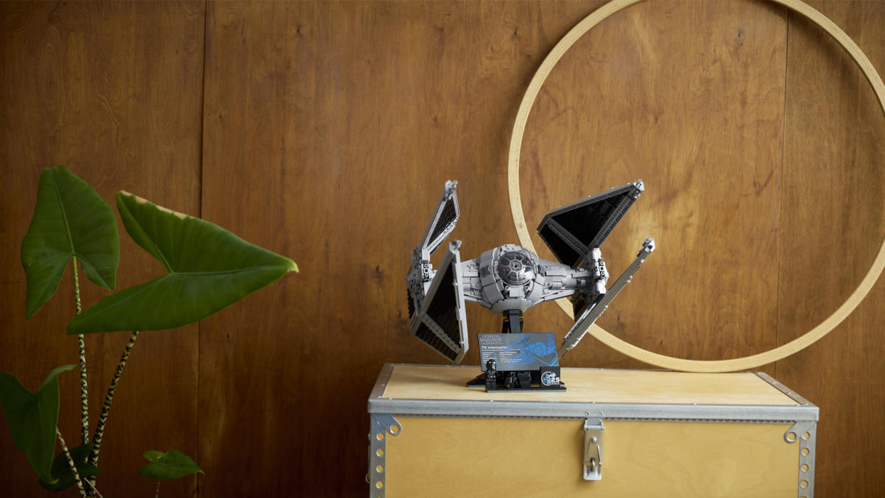  A plastic spaceship made out of plastic bricks sits on a shelf. 