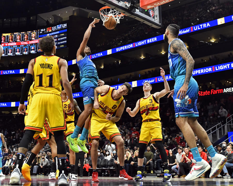 Charlotte Hornets forward PJ Washington, top left, jumps over Atlanta Hawks forward Danilo Gallinari to score a basket during the second half of an NBA basketball game on Sunday, Dec. 5, 2021, in Atlanta. (AP Photo/Edward M. Pio Roda)