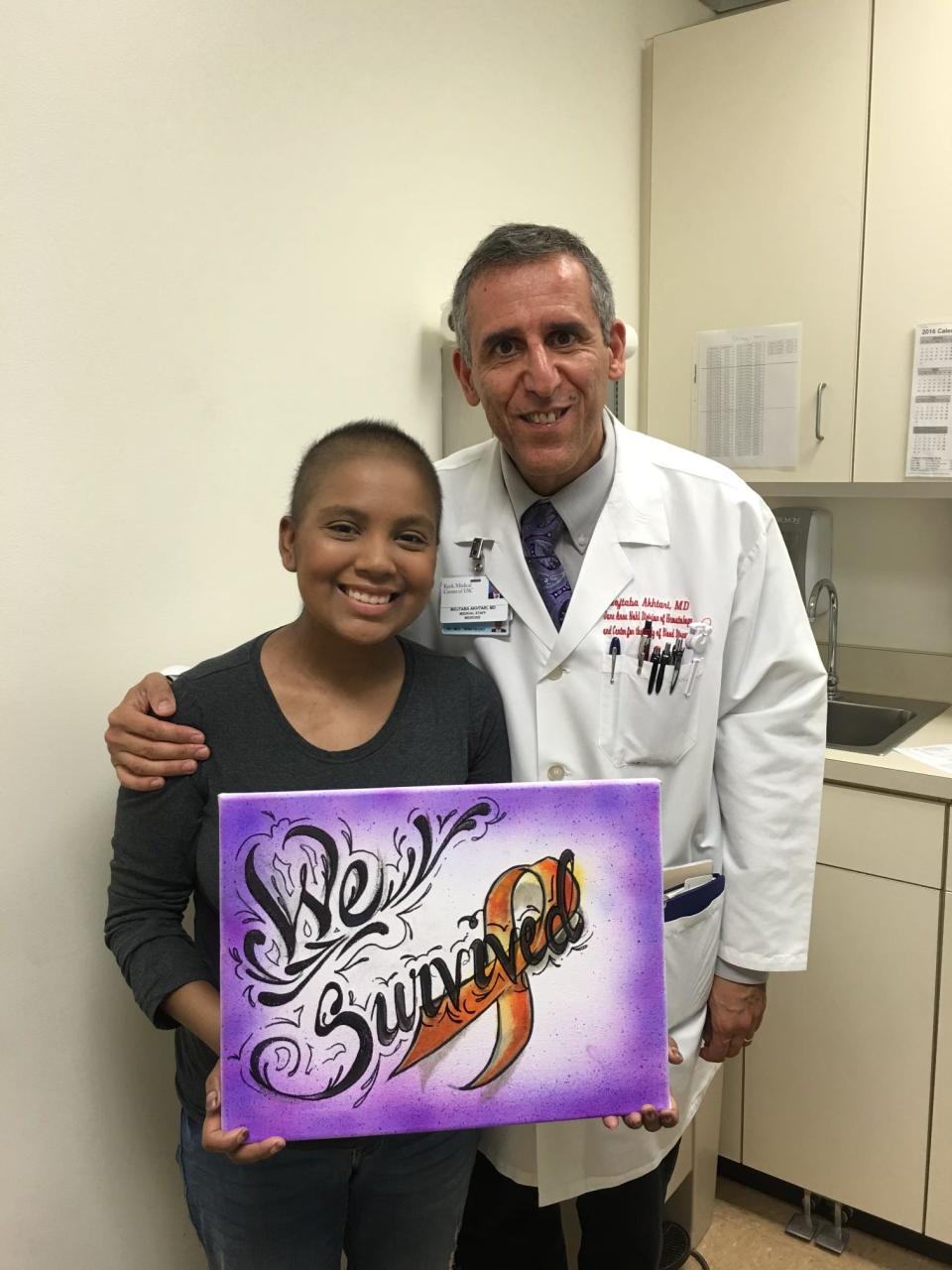 Cancer survivor Krystina Cordova proudly poses with Dr. Mojtaba Akhtari, her bone marrow transplant physician.