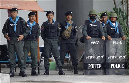 Police officers stand guard while anti-government protesters rally outside Thailand's Finance Ministry in central Bangkok April 2, 2014. Gunmen opened fire on a group of Thai anti-government protesters driving away from a Bangkok rally on Tuesday, killing one, wounding four and raising tension in a political crisis that has gripped the country for months. REUTERS/Chaiwat Subprasom