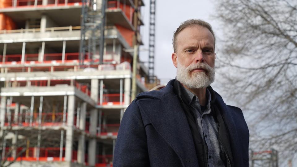 Winona Avenue resident James Hayes stands in front of the 2070 Scott Street high-rise development construction site.