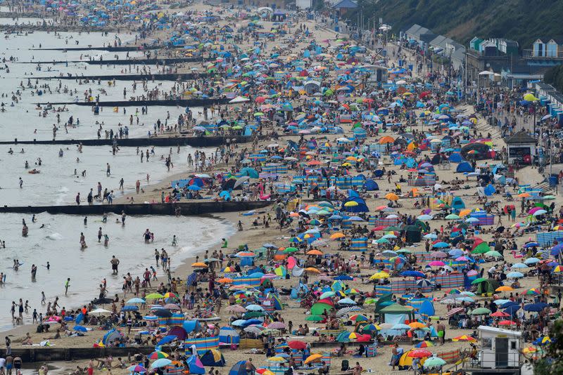 FILE PHOTO: People enjoy Bournemouth Beach during an unusual heat wave in Bournemouth, England