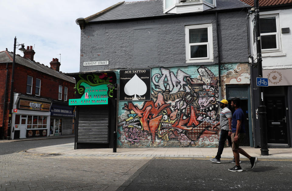 People walk past a closed Tattoo studio in Sunderland, following the outbreak of the coronavirus disease (COVID-19), Sunderland, Britain, June 2, 2020. REUTERS/Lee Smith