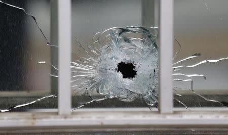 A bullet's impact is seen on a window at the scene after a shooting at the Paris offices of Charlie Hebdo, a satirical newspaper, January 7, 2015. REUTERS/Jacky Naegelen
