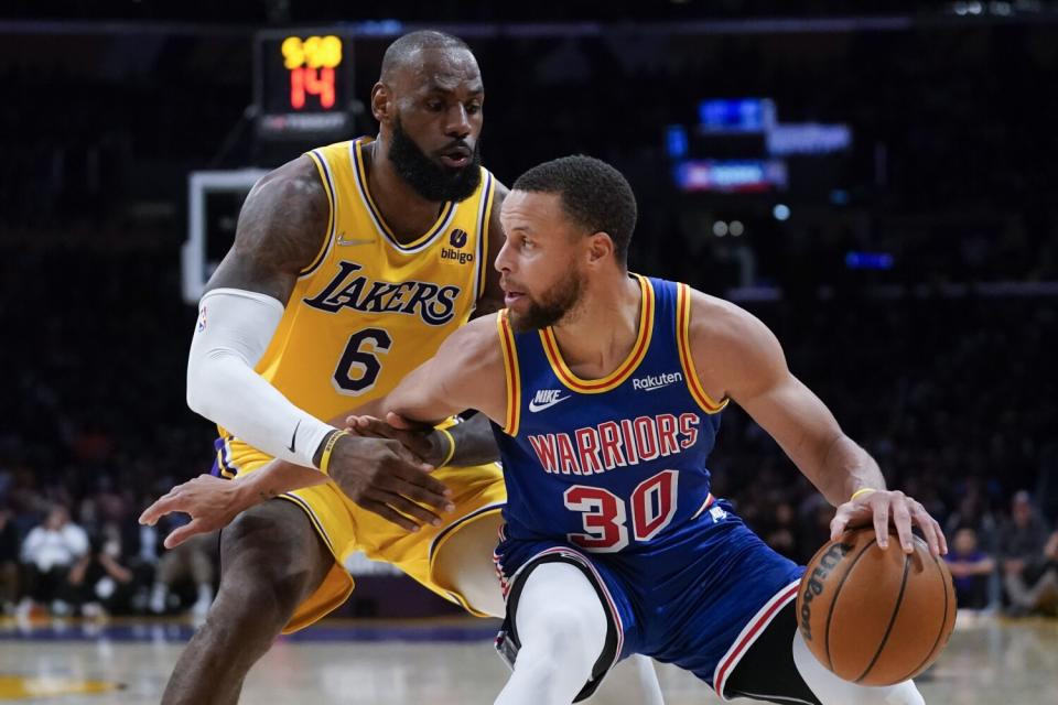 The Lakers' LeBron James defends the Warriors' Stephen Curry during the second half March 5, 2022.