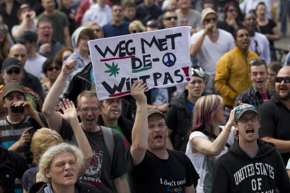 A demonstrator carries a sign reading "Get Rid of the Weed Pass" during a protest rally against the new marijuana buying policy in Maastricht, southern Netherlands, Tuesday May 1, 2012. A policy barring foreign tourists from buying marijuana in the Netherlands goes into effect in parts of the country Tuesday, with a protest planned in the southern city of Maastricht. Weed is technically illegal in the Netherlands, but it is sold openly in small amounts in designated cafes under the country's famed tolerance policy. The government has said that as of May 1, only holders of a "weed pass" will be allowed to purchase the drug, and nonresidents aren't eligible. (AP Photo/Peter Dejong)