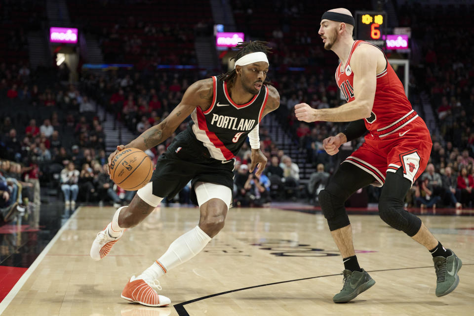 Portland Trail Blazers forward Jerami Grant, left, drives to the basket against Chicago Bulls guard Alex Caruso during the first half of an NBA basketball game in Portland, Ore., Sunday, Jan. 28, 2024. (AP Photo/Troy Wayrynen)