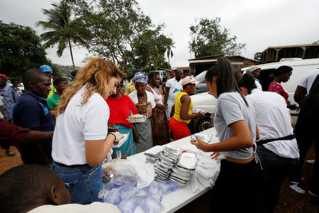 A non-governmental organisation (NGO) is seen distributing meals to victims of the mudslide at the internally displaced persons camp in Regent, Sierra Leone August 19, 2017. REUTERS/Afolabi Sotunde