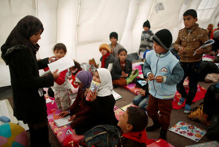 Displaced Iraqi children attend a class in a tent school set by United Nations Children's Fund (UNICEF) at Hassan Sham camp, east of Mosul, Iraq December 8, 2016. REUTERS/Mohammed Salem