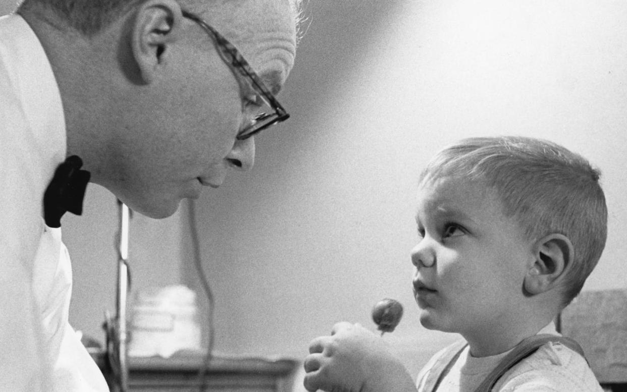 <span class="caption">An unidentified doctor talks with a boy who holds a lollipop reward after participating in a measles vaccine research program in Upper Darby, Pennsylvania, in 1963. </span> <span class="attribution"><a class="link " href="https://www.gettyimages.com/detail/news-photo/an-unidentified-medical-professional-talks-with-a-boy-who-news-photo/1271741549?adppopup=true" rel="nofollow noopener" target="_blank" data-ylk="slk:NASA/PhotoQuest/Getty Images;elm:context_link;itc:0;sec:content-canvas">NASA/PhotoQuest/Getty Images</a></span>