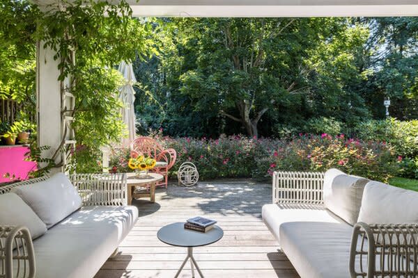 A covered patio offers a front-row seat to the lush landscaping, filled with specimen trees and flowering gardens.