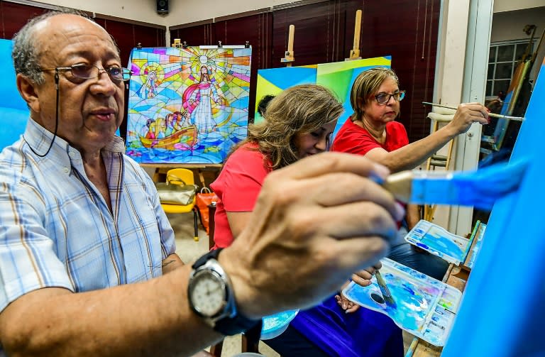 Ecuadoran artist Ivan Delgado and his students at work on the mural bearing a message against racism and xenophobia