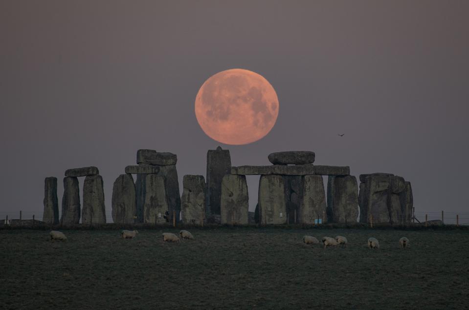 The full moon sets behind Stonehenge on April 27, 2021 in Amesbury, England.
