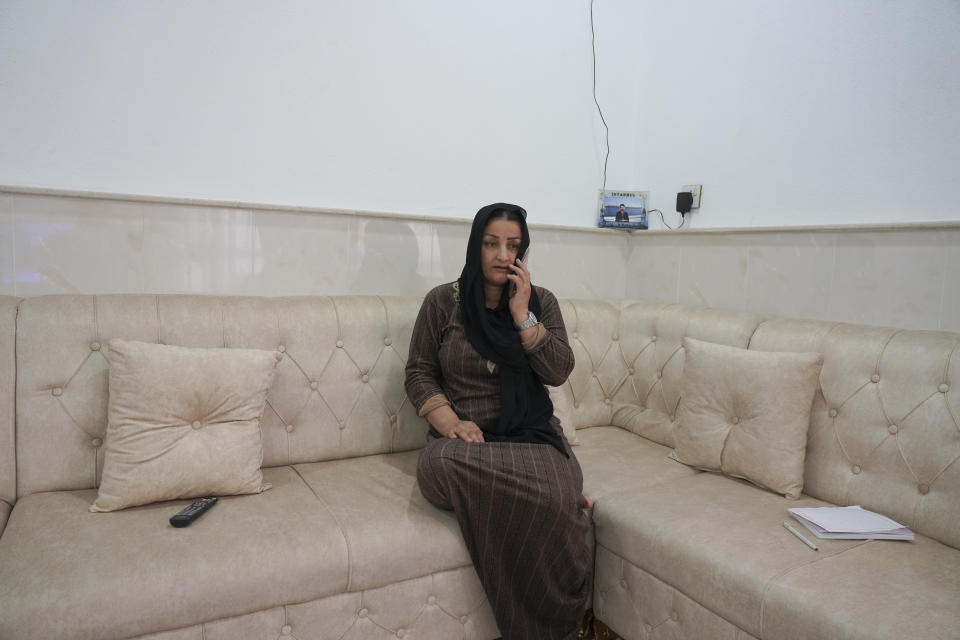 Adla Salim, the mother of the 19-year-old Sarkawt Imsat, stranded on the Belarus border, speaks on the phone at her home in Dohuk, Iraq, Friday, Nov. 12, 2021. Sarkawt is among thousands from the Middle East who have been trying to slip into the EU in recent months using a backdoor quietly opened by non-EU member Belarus.(AP Photo/Rashid Yahya)