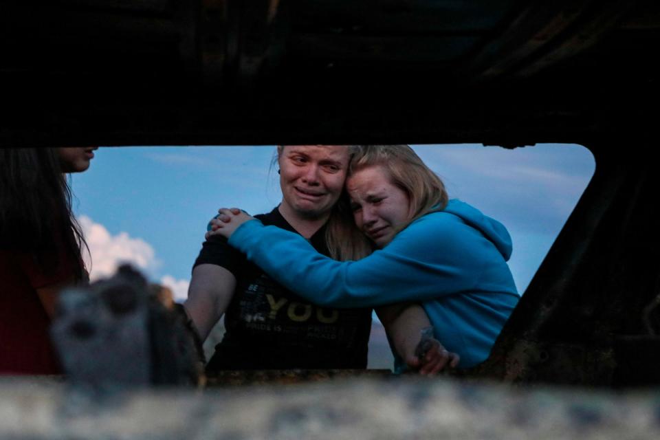 Members of the LeBaron family mourn while they watch the burned car where part of the nine murdered members of the family were killed and burned during an gunmen ambush on Bavispe, Sonora mountains, Mexico, on November 5, 2019.