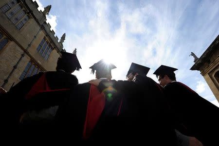 A group of graduates gather outside the Sheldonian Theatre to have their photograph taken after a graduation ceremony at Oxford University, Oxford, England, May 28, 2011. REUTERS/Paul Hackett/Files