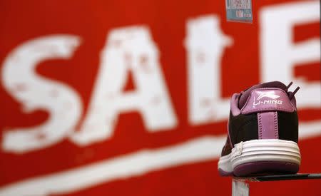 A Li Ning shoe is displayed in front of a promotional board at a shop in Beijing, in this August 6, 2013 file picture. REUTERS/Kim Kyung-Hoon