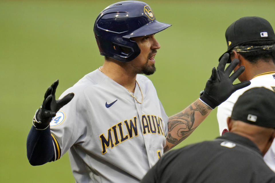 Milwaukee Brewers' Jace Peterson, center, celebrates as he stands on third base after hitting an RBI triple off Pittsburgh Pirates starting pitcher Wil Crowe during the second inning of a baseball game in Pittsburgh, Thursday, July 1, 2021. (AP Photo/Gene J. Puskar)