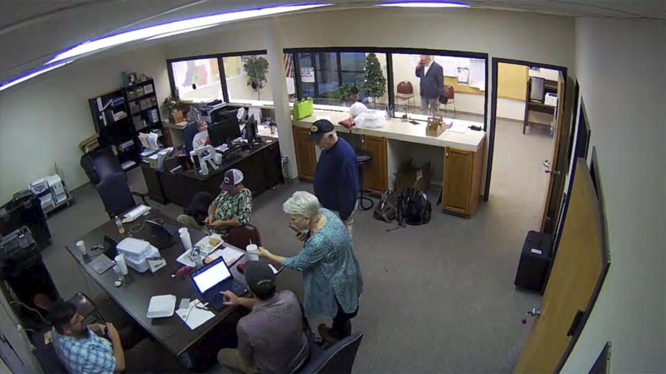 FILE - In this Jan. 7, 2021, image taken from Coffee County, Ga., security video, Cathy Latham, center, is seen in the local elections office in Douglas, Ga., while a computer forensics team was there to make copies of voting equipment. Latham was the county Republican Party chair at the time. (Coffee County, Georgia via AP, File)