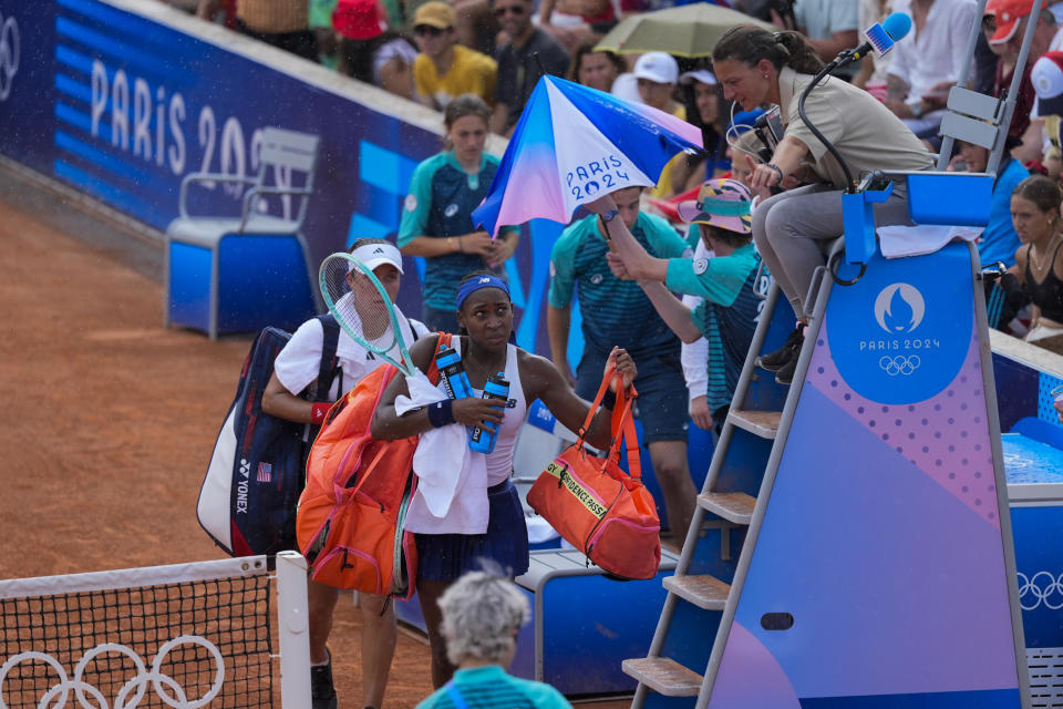 Coco Gauff y Jessica Pegula de los Estados Unidos abandonan la cancha después de que su duelo ante las checas Linda Noskova y Karolina Muchova se suspendió por lluvia el miércoles 31 de julio del 2024. (AP Foto/Andy Wong)