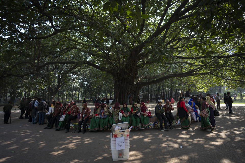 Election workers sit under a Banyan tree as they wait at a distribution centre to be deputed to various polling stations in Dhaka, Bangladesh, Saturday, Jan. 6, 2024. Bangladesh’s main opposition party has enforced a 48-hour general strike from Saturday across the South Asian nation as the nation is ready to hold its next general election a day later. (AP Photo/Altaf Qadri)