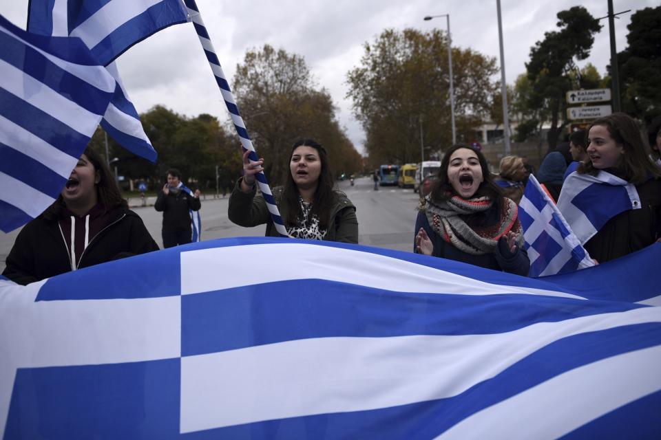 Teenagers wave Greek flags during a protest in the northern Greek city of Thessaloniki, Thursday, Nov. 29, 2018. About 1,000 high school students protested against government efforts to end a three-decade-old dispute with neighboring Macedonia. (AP Photo/Giannis Papanikos)