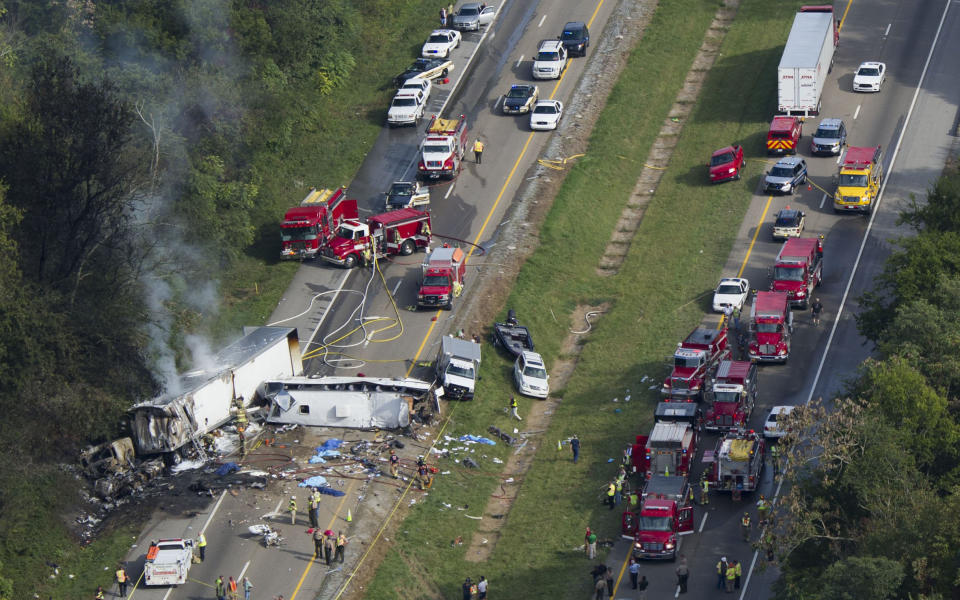 The scene of a fatal three-vehicle accident involving a church bus is seen October 2, 2013, near Dandridge, Tenn. Investigators concluded, Monday, April 28, 2014, a blown tire caused the accident in which the bus crossed the Interstate 40 median and crash into an SUV and tractor-trailer, killing eight people and injuring 14. (AP Photo/Knoxville News Sentinel, Paul Efird)