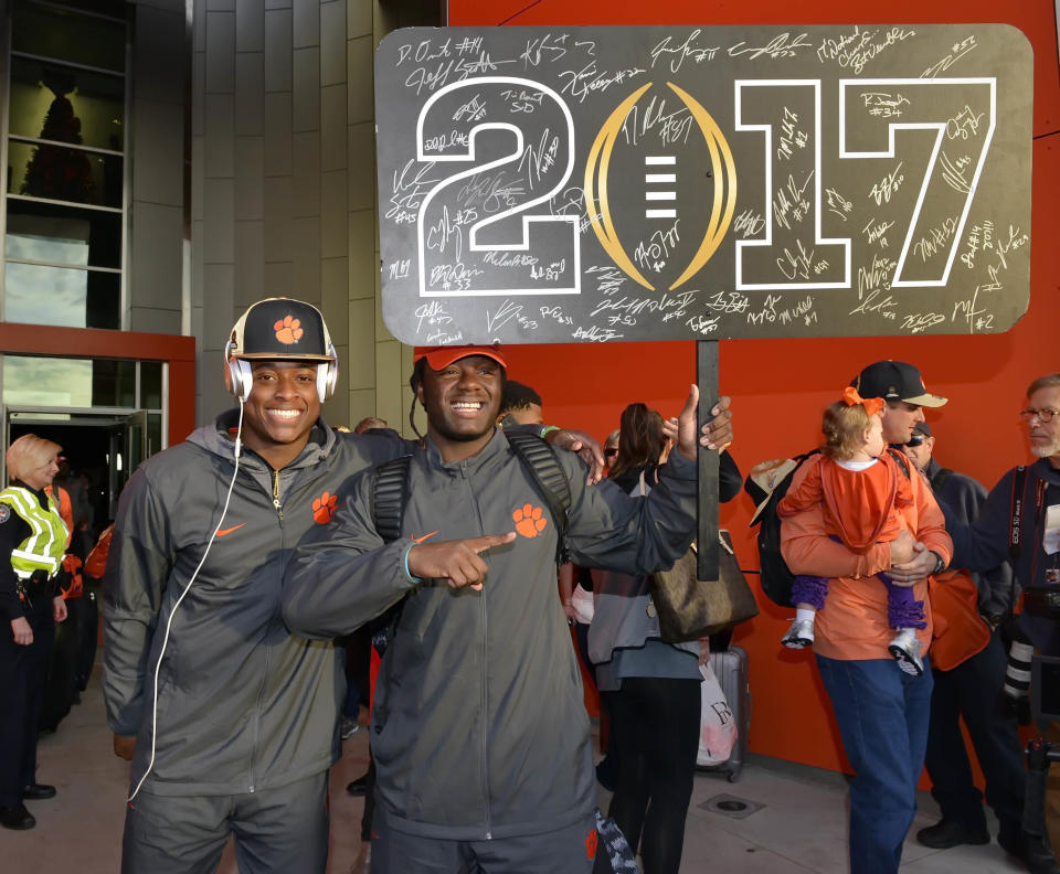 Clemson's Jalen Williams, right, and K'Von Wallace hold a sign after returning Tuesday, Jan. 10, 2017, in Clemson, S.C., the day after the Tigers defeated Alabama 35-31 in the College Football Playoff championship NCAA college football game in Tampa. (AP Photo/Richard Shiro)