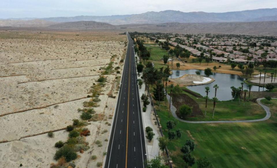 A lush green golf course is seen next to dry desert landscape in Palm Desert, California, on 29 June.