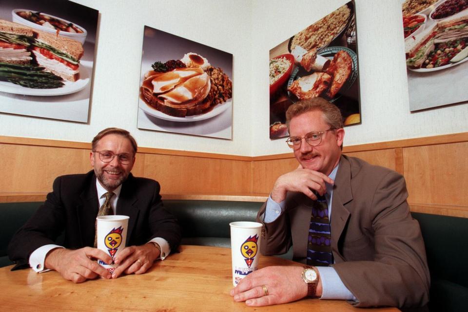 Kevin S. Relyea, left, and A. William Allen III sitting in suits at a table at Koo Koo Roo in Santa Monica