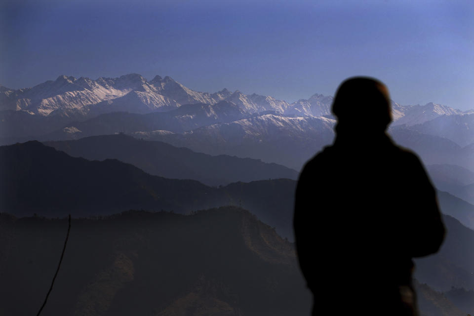 An Indian army soldier looks towards the snow-covered Pir Panjal range of mountains from one of their forward post at the Line of Control (LOC) between India and Pakistan border, in Poonch, about 248 kilometers (155 miles) from Jammu, India, Wednesday, Dec. 16, 2020. From sandbagged Indian army bunkers dug deep into the Pir Panjal mountains in the Himalayas, villages on the Pakistan-controlled side of Kashmir appear precariously close, on the other side of the Line of Control that for the past 73 years has divided the region between the two nuclear-armed rivals. Tens of thousands of soldiers from India and Pakistan are positioned along the two sides. The apparent calm is often broken by the boom of blazing guns, with each side accusing the other of initiating the firing. (AP Photo/Channi Anand)