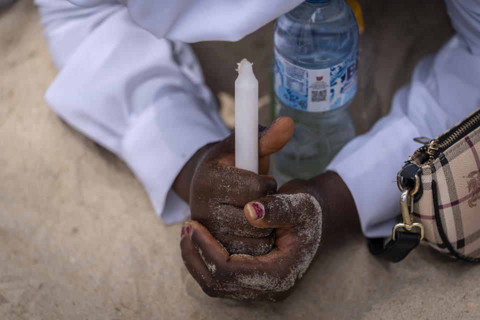 A member of the congregation prays on the sand floor during a church service in which they prayed for the country ahead of elections and against the forces of evil, at the Celestial Church of Christ Olowu Cathedral on Lagos Island in Nigeria Friday, Feb. 24, 2023. Nigerian voters are heading to the polls Saturday to select a new president following the second and final term of incumbent President Muhammadu Buhari. (AP Photo/Ben Curtis)