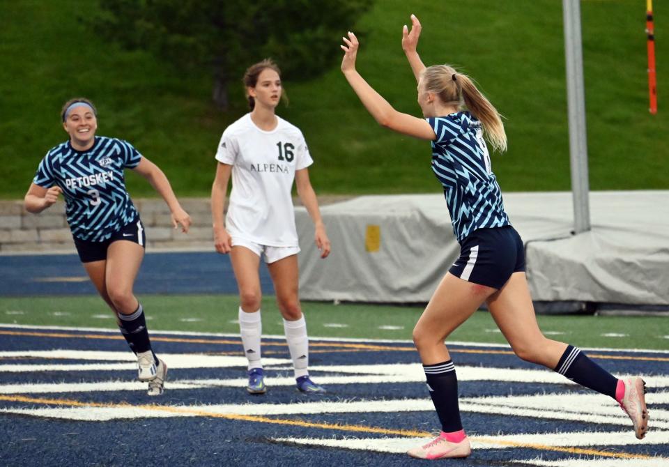 Petoskey's Lily Premo (left) runs over to celebrate with teammate Claire O'Donnell and others after scoring against Alpena Thursday.