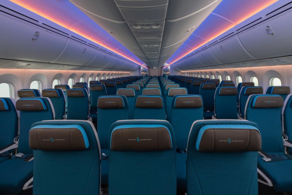 Blue seats and pink and purple ceiling lights in Hawaiian Airlines new Boeing 787-9 Dreamliners' main cabin.