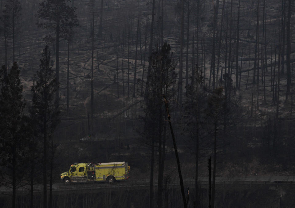 A fire truck drives past trees burned during the Las Conchas fire in Los Alamos, N.M., Thursday, June 30, 2011. Global warming is rapidly turning America into a stormy and dangerous place, with rising seas and disasters upending lives from flood-stricken Florida to the wildfire-ravaged West, according to a new U.S. federal scientific report released Tuesday, May 6, 2014. (AP Photo/Jae C. Hong)