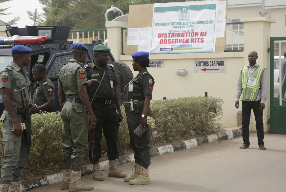 FILE- Police officers secured the entrance to the offices of the Independent National Electoral Commission in Yola, Nigeria, Friday, Feb. 15, 2019. A surge of violence targeting Nigeria's election commission offices and extremist attacks in remote communities are already raising concerns about the upcoming February elections in Africa's most populous nation. (AP Photo/Sunday Alamba, File)