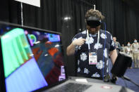 Gad Baruch Hinkis, of PatchXR, demonstrates the PatchWorld program during CES Unveiled before the start of the CES tech show Sunday, Jan. 7, 2024, in Las Vegas. PatchWorld is an augmented reality gaming platform that allows users to create virtual building blocks for music. (AP Photo/Ryan Sun)