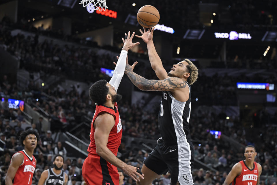 San Antonio Spurs' Jeremy Sochan, right, goes to the basket against Houston Rockets' Fred VanVleet during the first half of an NBA basketball game Tuesday, March 12, 2024, in San Antonio. (AP Photo/Darren Abate)